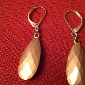 A set of gold dangling earrings.